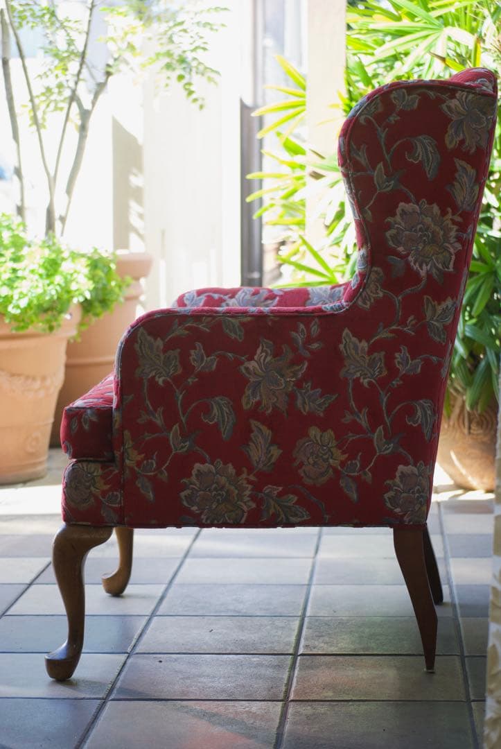 赤い花柄のクラシカルなウィングバックチェア。存在感がありインテリアのアクセントに