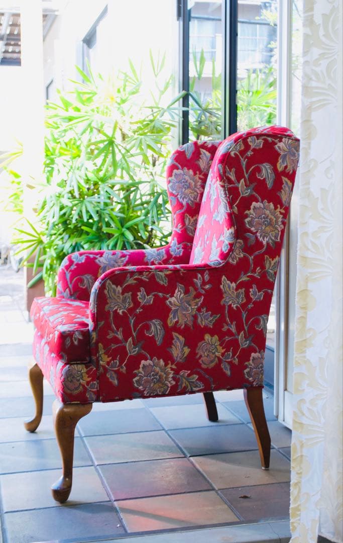 赤い花柄のクラシカルなウィングバックチェア。存在感がありインテリアのアクセントに