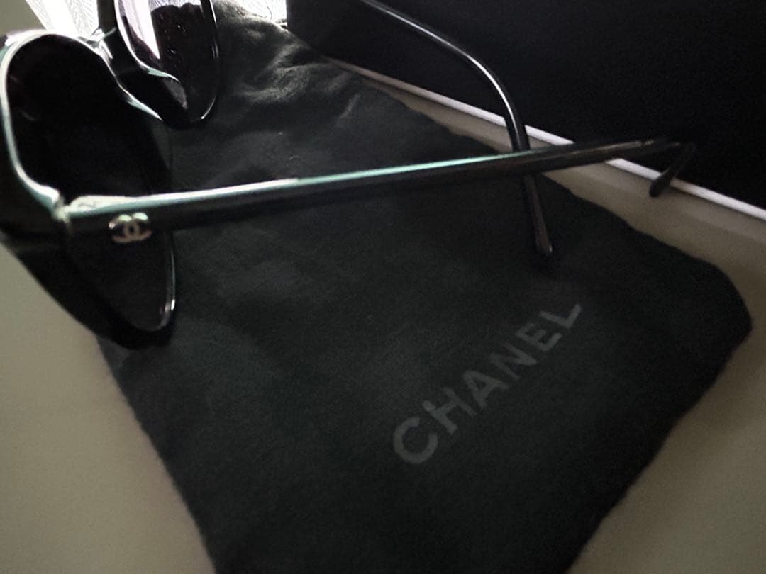 ブラックのCHANELサングラス、ケース、内袋、ロゴ付き。