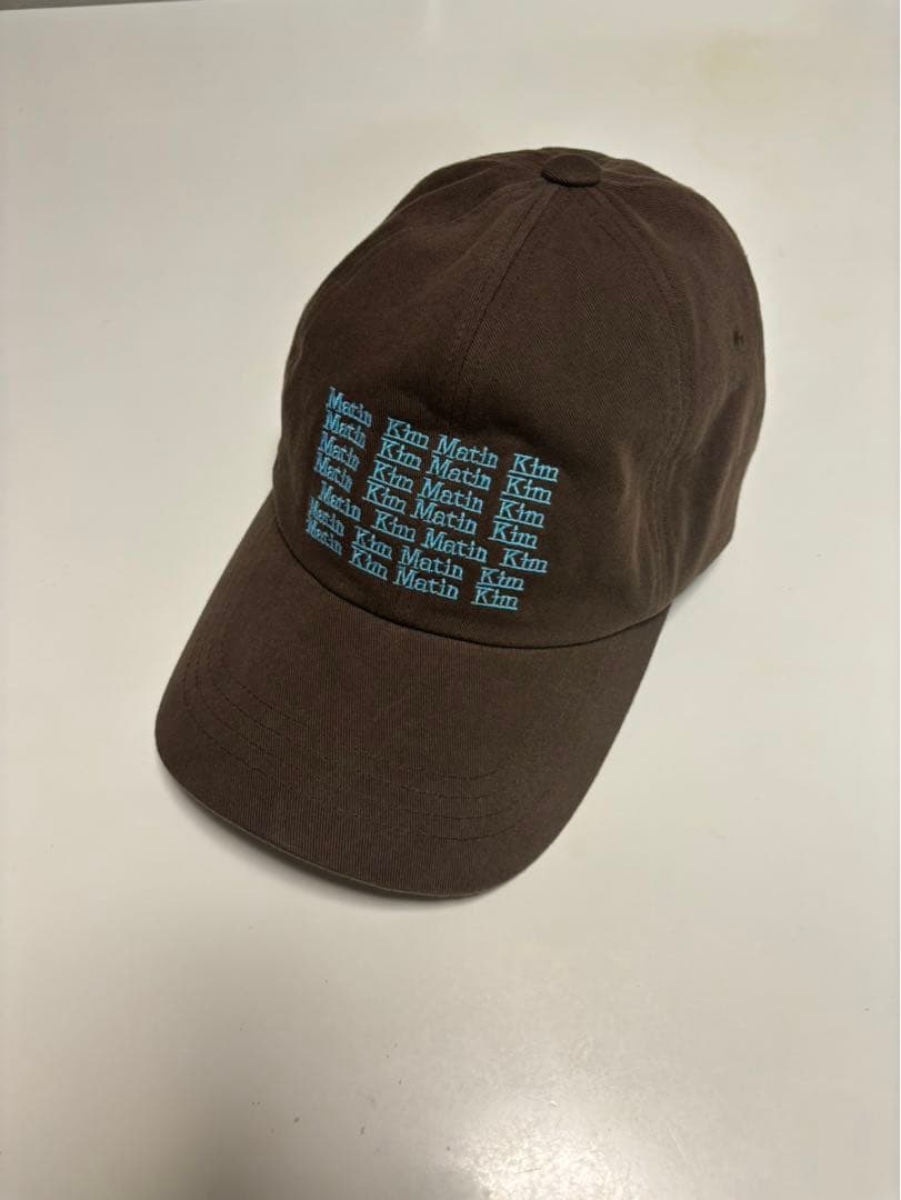 Matin Kim ブラウンキャップ 青色テキストプリント