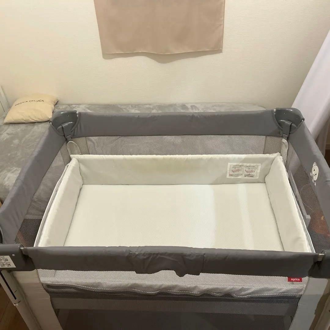 グレーの折りたたみ式ベビーベッド
