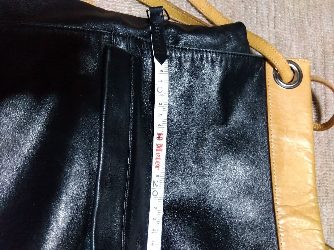 レザー製リュック 黒と黄 Mのロゴ