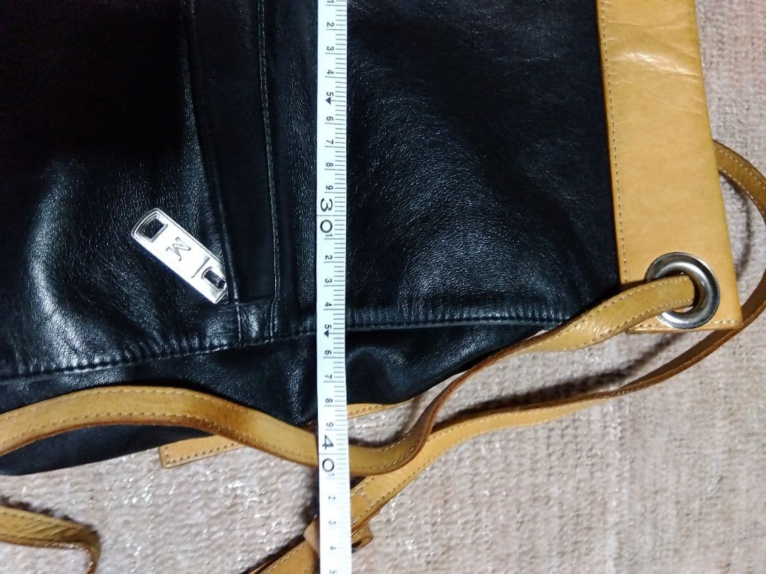 レザー製リュック 黒と黄 Mのロゴ