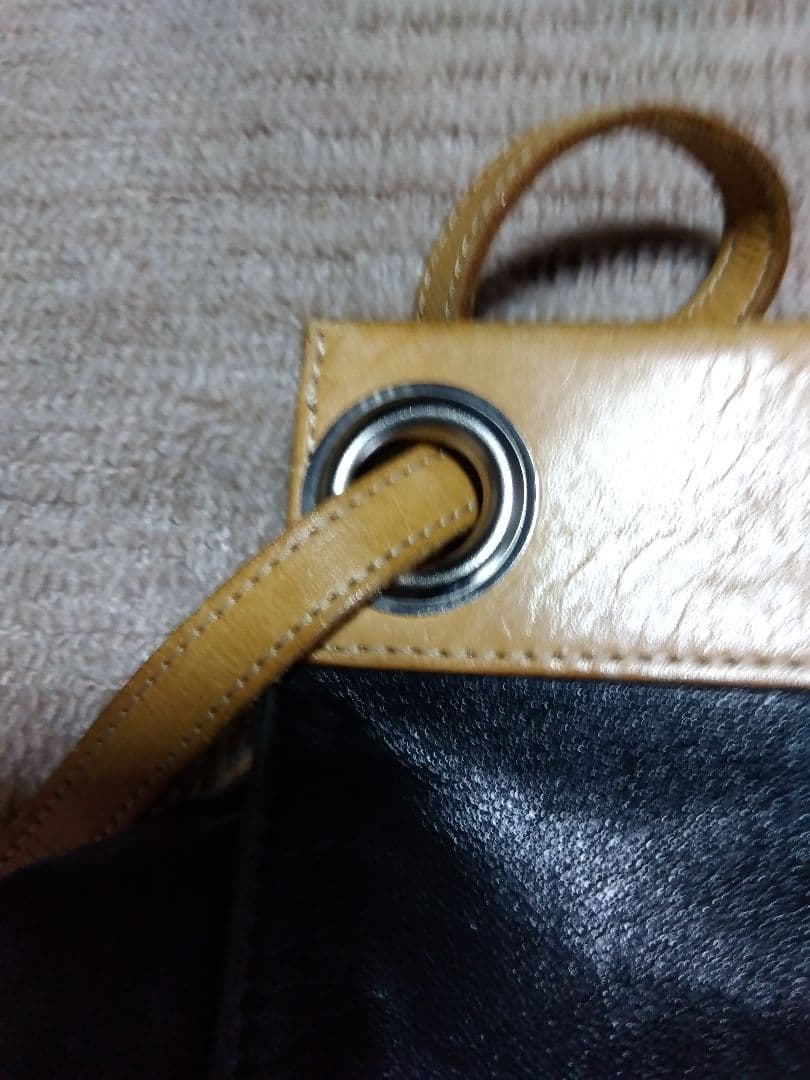 レザー製リュック 黒と黄 Mのロゴ