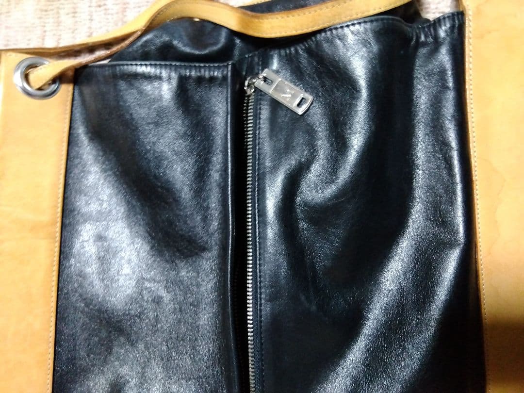 レザー製リュック 黒と黄 Mのロゴ