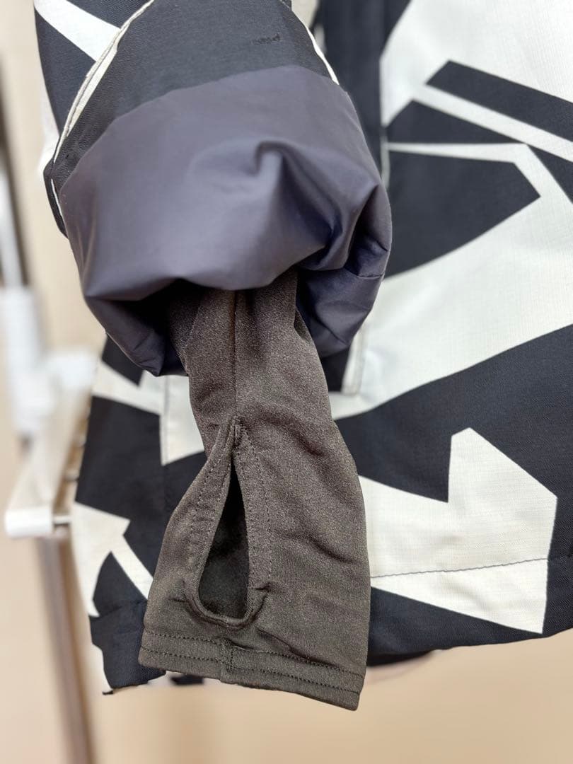 『白と黒の幾何学模様が特徴的なスノーボードウェアのジャケット』