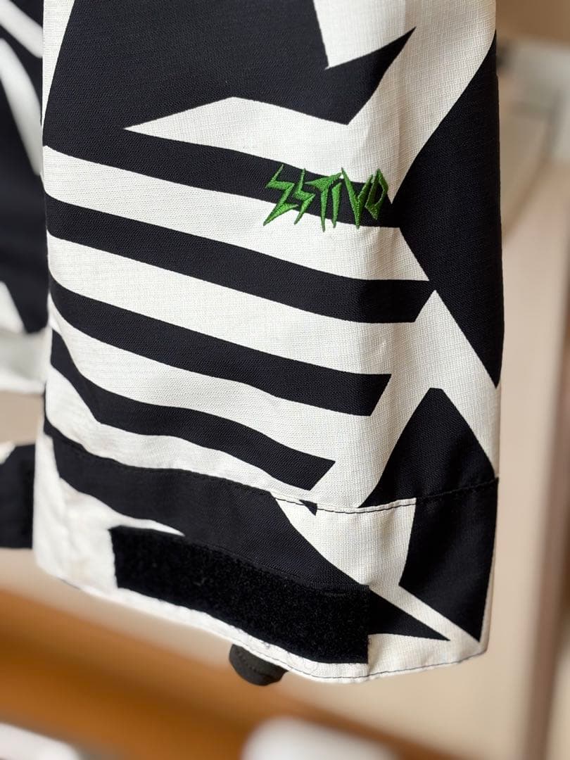 『白と黒の幾何学模様が特徴的なスノーボードウェアのジャケット』