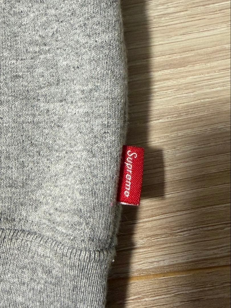 Sの刺繍が特徴のグレーのフルジップパーカー。